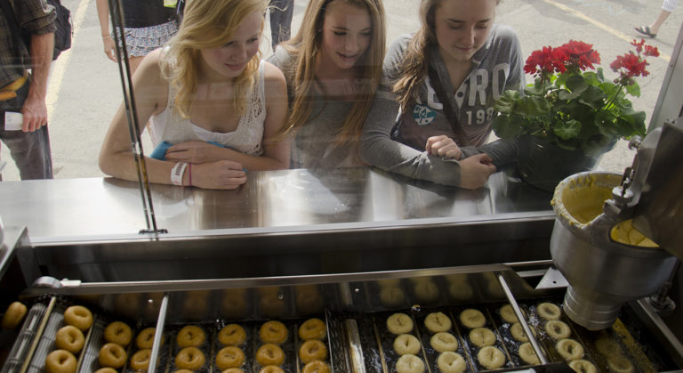 Girls watching Cin City Mini Donuts being made fresh before their eyes
