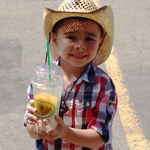 Little cowboy holding a Lemon Heaven lemonade