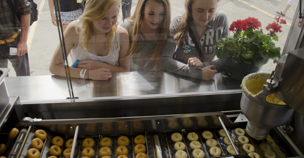 Three girls watching Cin City Mini Donuts being made